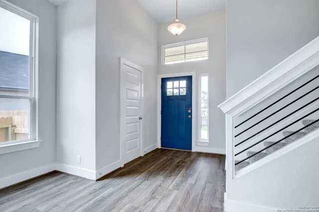 a view of an entryway with wooden floor and cabinet
