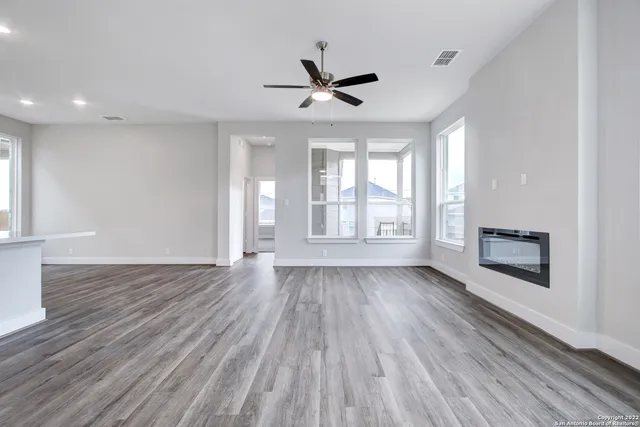 a view of wooden floor fire place refrigerator and window in a room