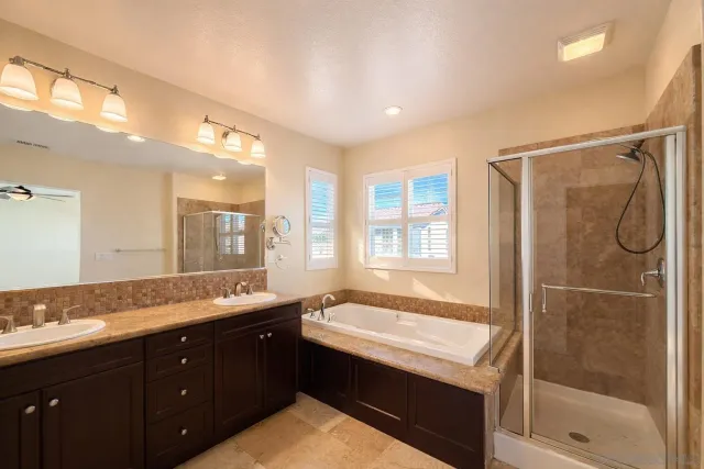 a bathroom with a granite countertop sink mirror and a bathtub