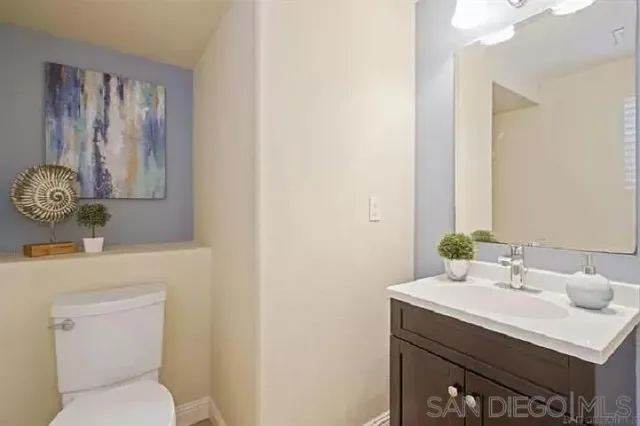 a bathroom with a sink mirror and toilet