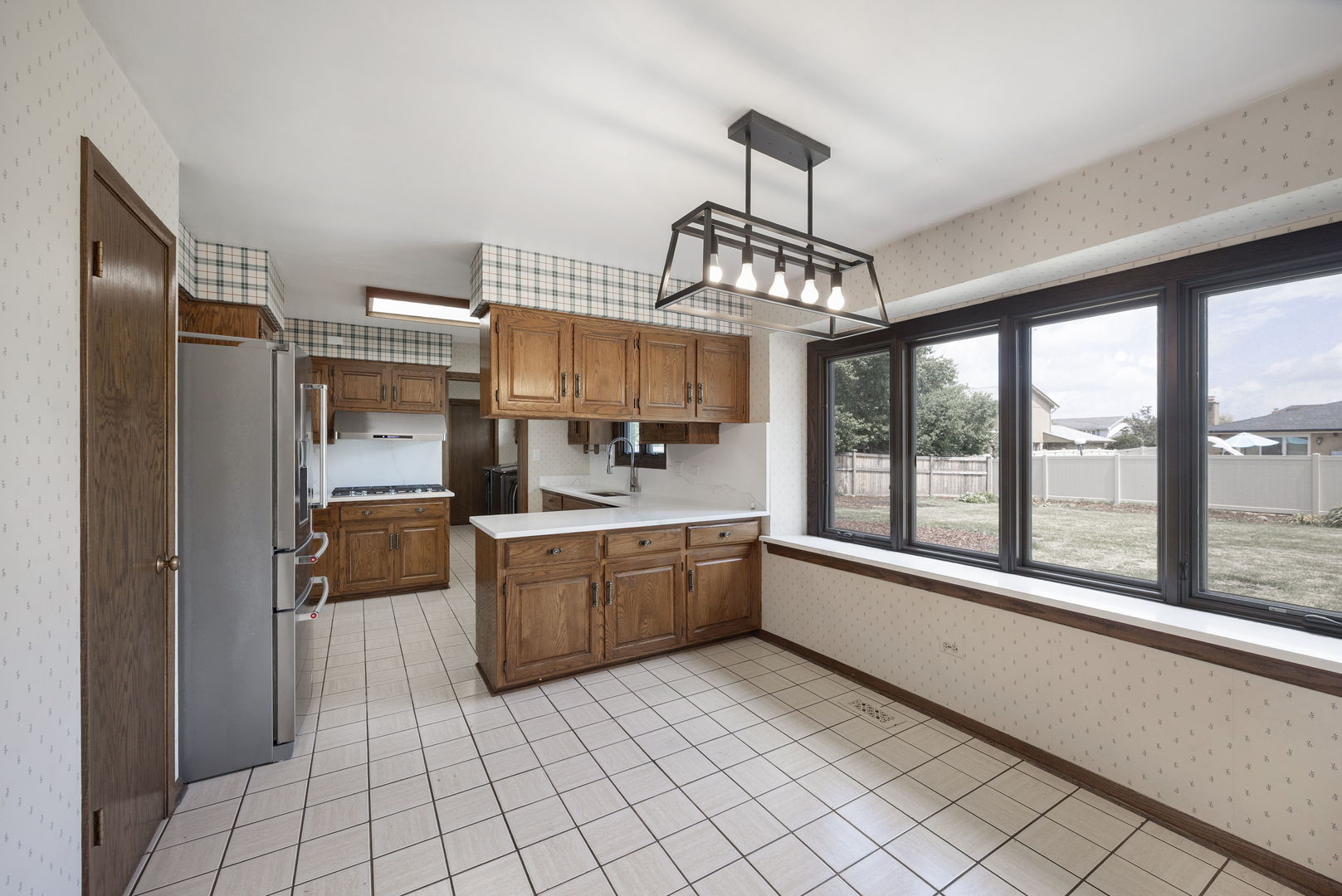 6723 Kingswood Road Willowbrook, IL 60527 - Photo 18 of 51 a large kitchen with white cabinets and stainless steel appliances