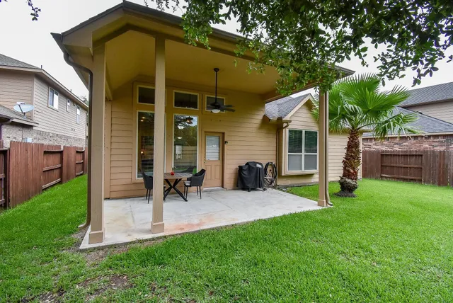 a view of a chair and table in backyard of the house
