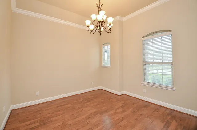 an empty room with windows and chandelier