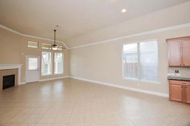 a view of an empty room with a window and fireplace