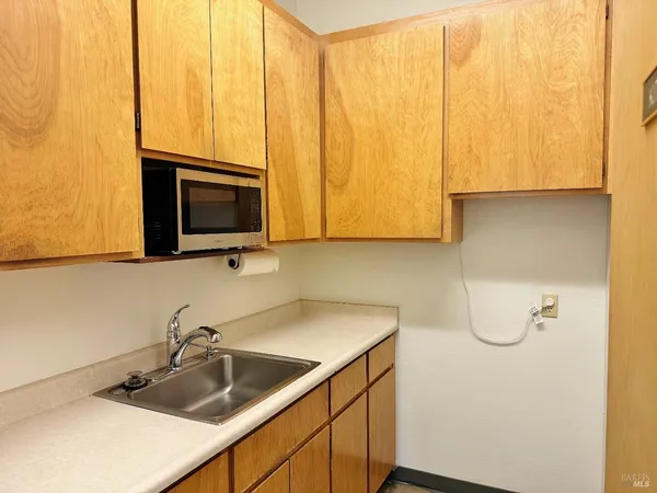 a kitchen with a sink a microwave and cabinets