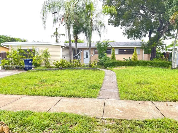 a front view of a house with a yard and potted plants