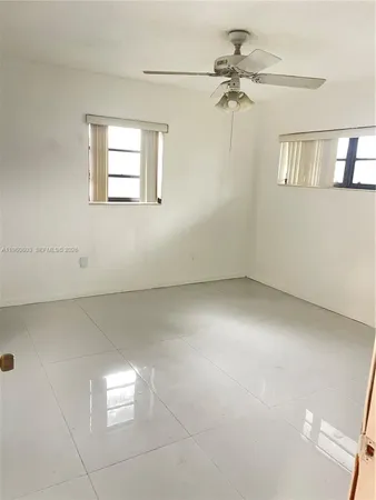 a view of a room with a ceiling fan and window