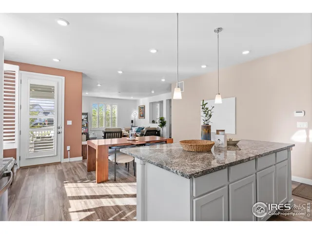 a kitchen with granite countertop kitchen island sink stove and wooden floor