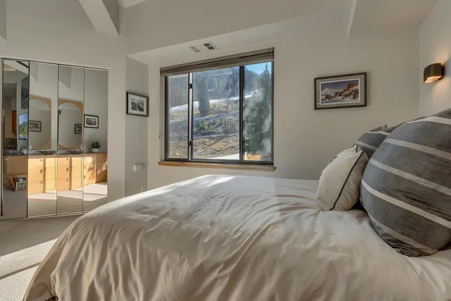 a bed sitting in a bedroom next to a window