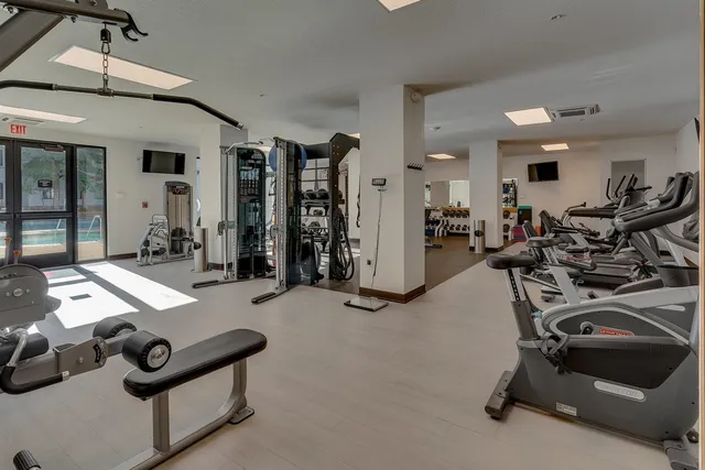 a room with gym equipment and a chandelier