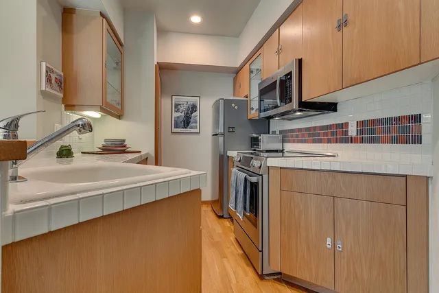 a kitchen with stainless steel appliances a sink stove and refrigerator