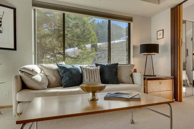 a living room with furniture and a floor to ceiling window