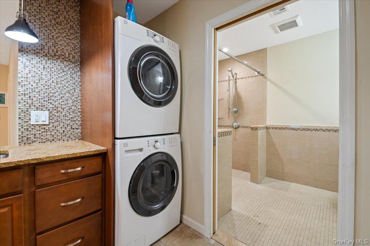 33 Fleets Cove Road Huntington, NY 11743 - Photo 30 of 42 Laundry area featuring stacked washer and clothes dryer and light tile patterned floors