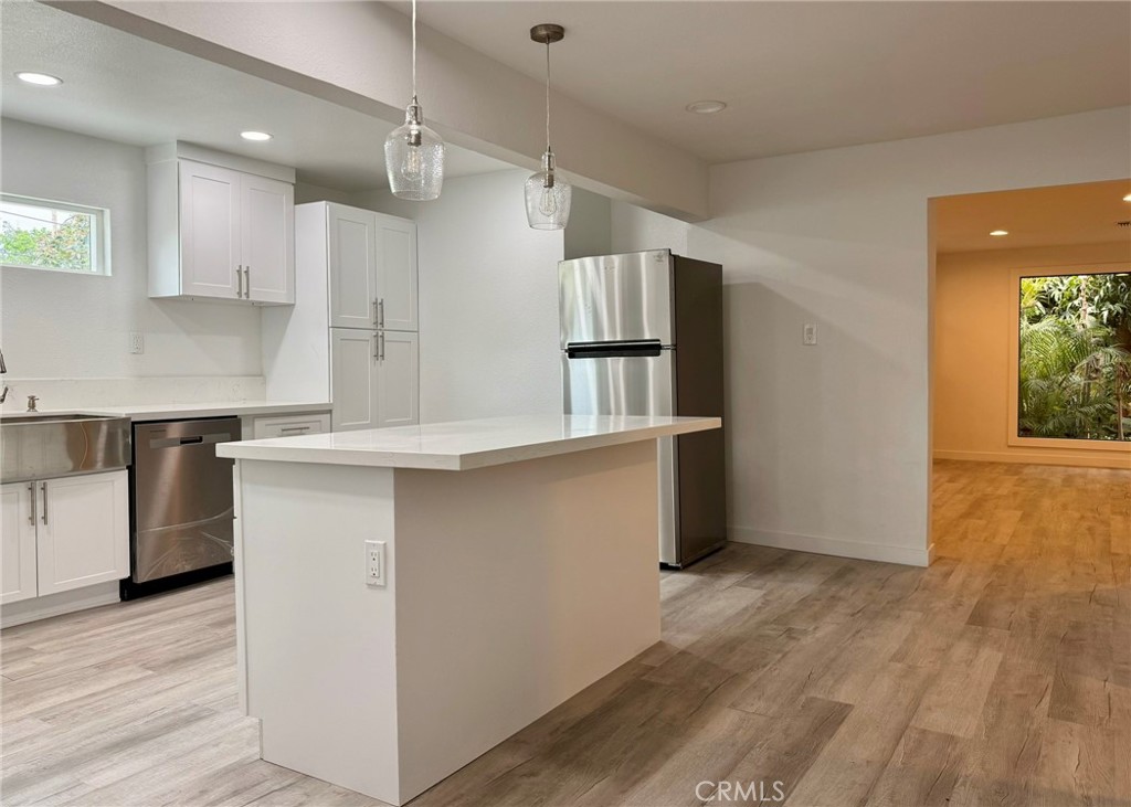 1362 South Downey Road Los Angeles, CA 90023 - Photo 16 of 30 a kitchen with kitchen island a counter top space wooden floor and appliances
