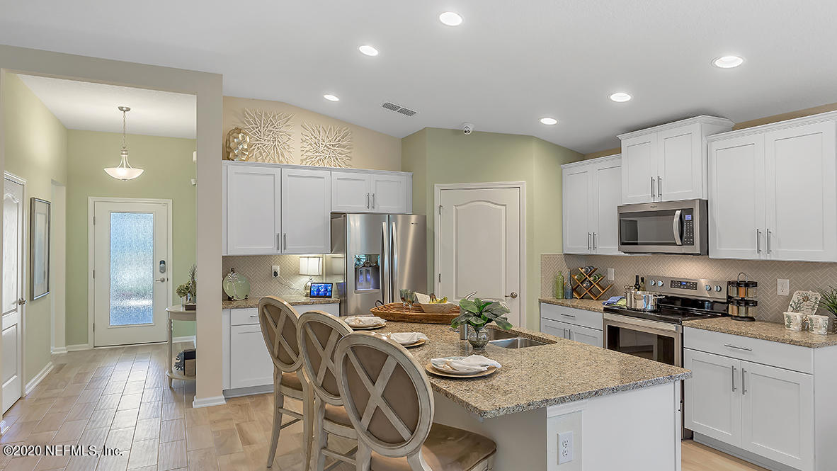 100 Palace Drive St. Augustine, FL 32084 - Photo 5 of 27 a kitchen with stainless steel appliances granite countertop a stove a sink a refrigerator and a dining table with wooden floor