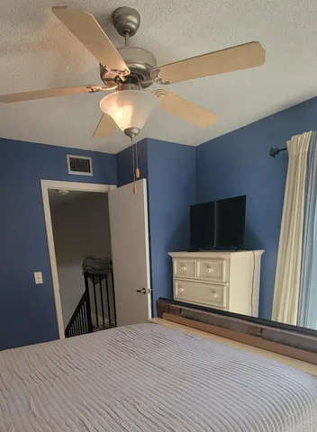 a bed sitting in a bedroom next to a lamp