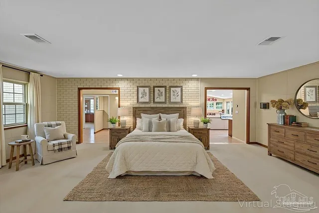 a spacious bedroom with a bed a table and chair