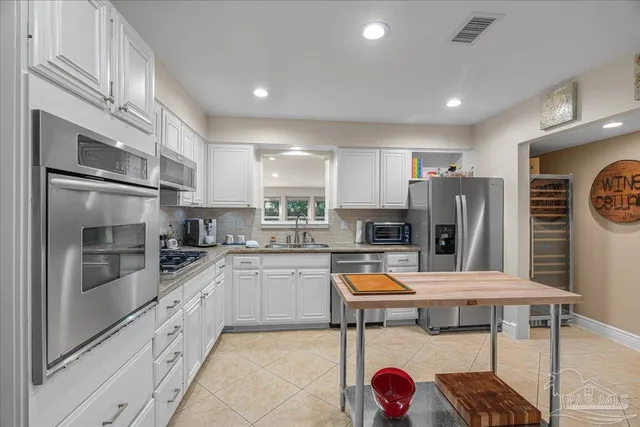 a kitchen with stainless steel appliances granite countertop a refrigerator and a stove top oven
