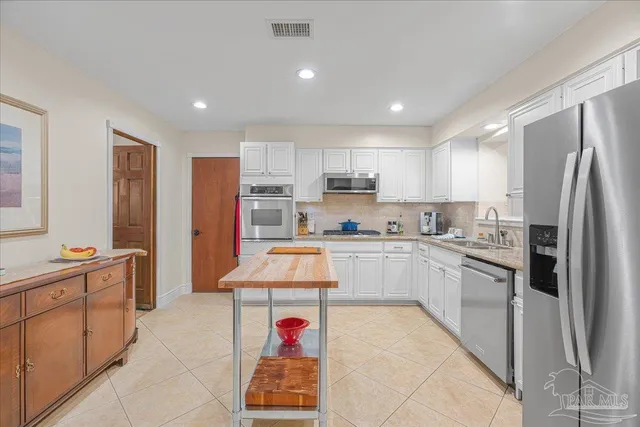 a kitchen with stainless steel appliances granite countertop a refrigerator and a sink