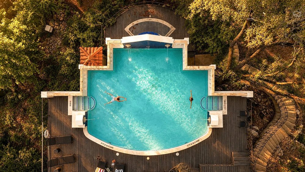 1815 Rue De St Tropez Austin, TX 78746 - Photo 6 of 40 Resort-style pool with integrated steps, surrounded by extensive wood-finish decking