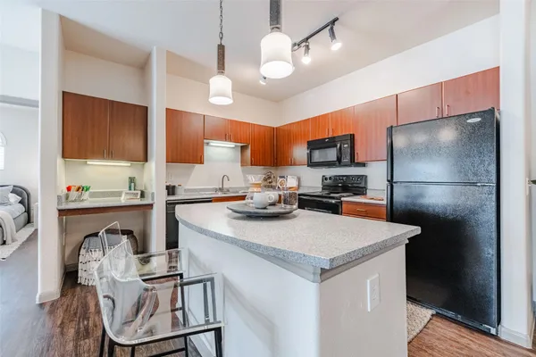 a kitchen with granite countertop a sink a counter top space appliances and cabinets