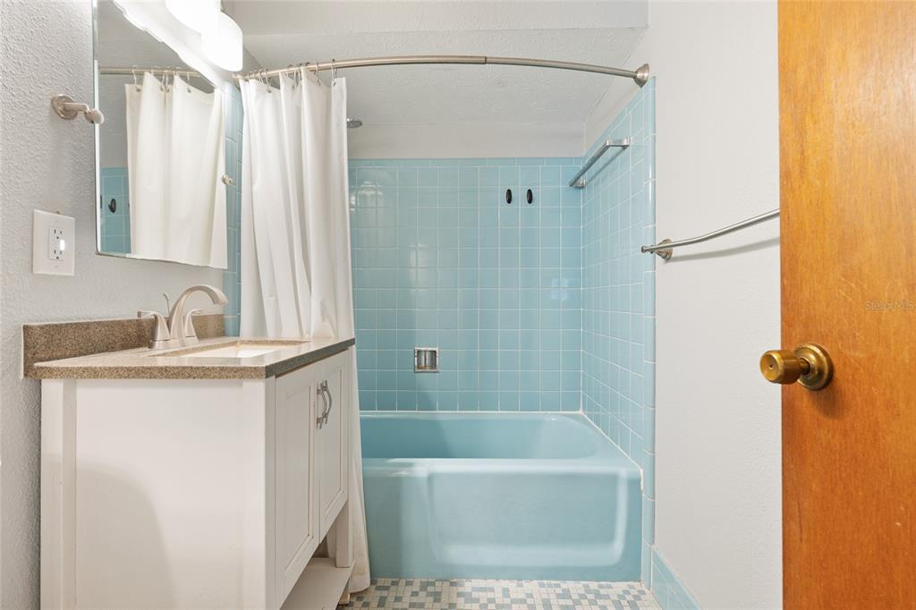 630 Northwest 34th Street Gainesville, FL 32607 - Photo 31 of 84 a bathroom with a granite countertop sink a mirror a shower and a bathtub
