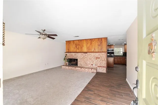 a view of an empty room with fireplace and a window