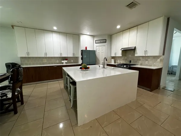 a kitchen with a sink a counter top space cabinets and stainless steel appliances