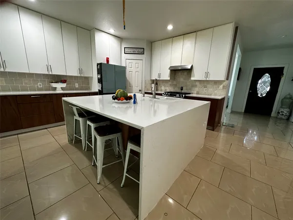 a kitchen with a sink a microwave and cabinets