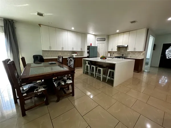 a large kitchen with stainless steel appliances a stove a sink and a refrigerator