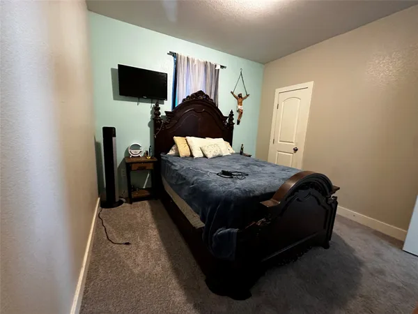 a bedroom with a bed window and a flat screen tv