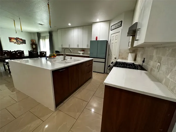 a kitchen with a sink a counter top space a stove and cabinets
