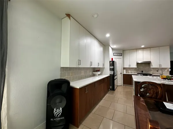 a kitchen with a sink and a stove top oven with wooden floor
