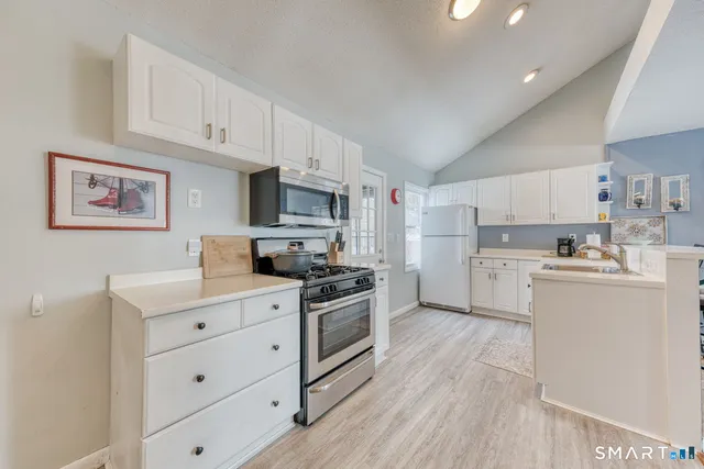 a kitchen with white cabinets and sink