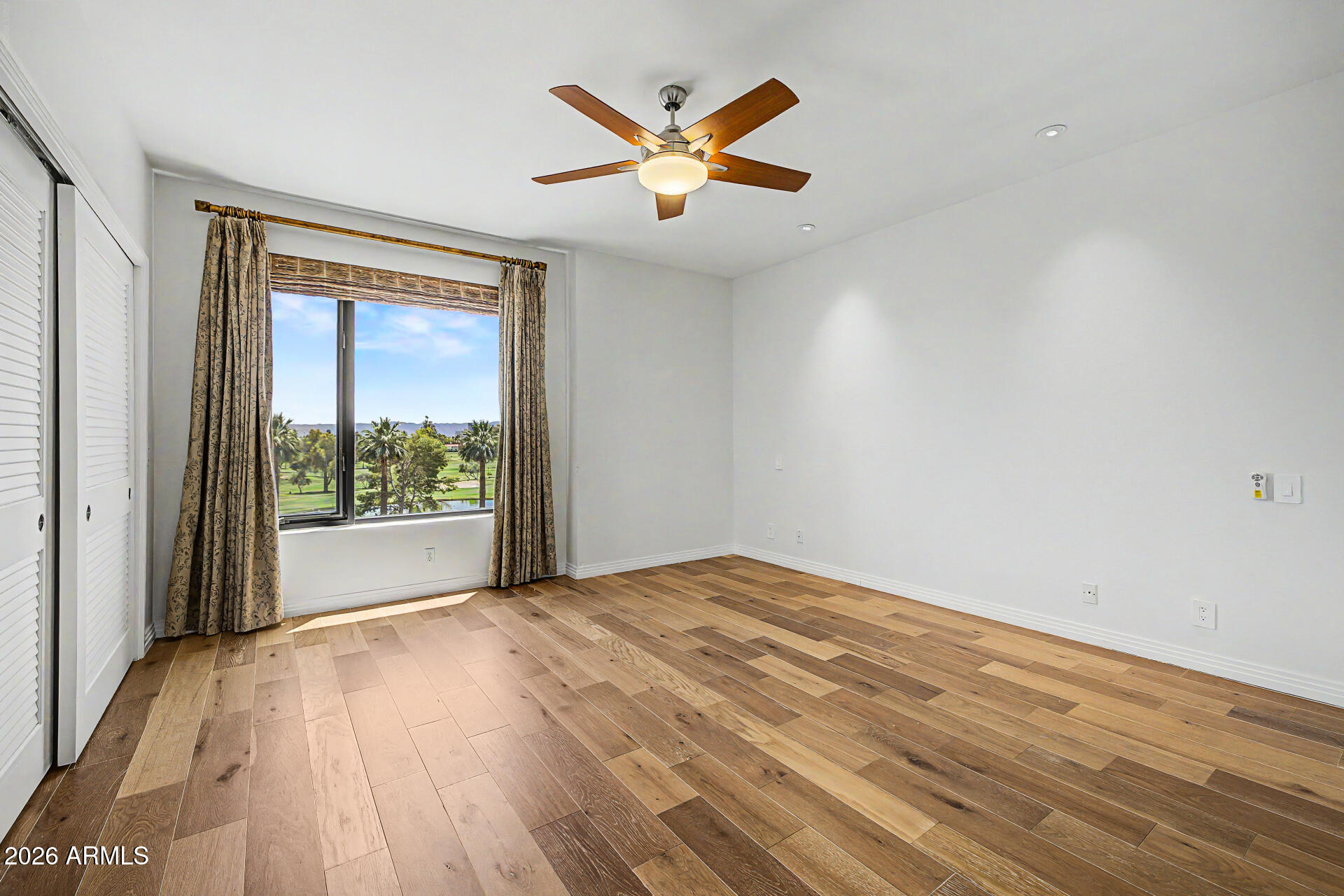 1040 East Osborn Road, Unit 402 Phoenix, AZ 85014 - Photo 50 of 96 a view of an empty room with wooden floor and a window