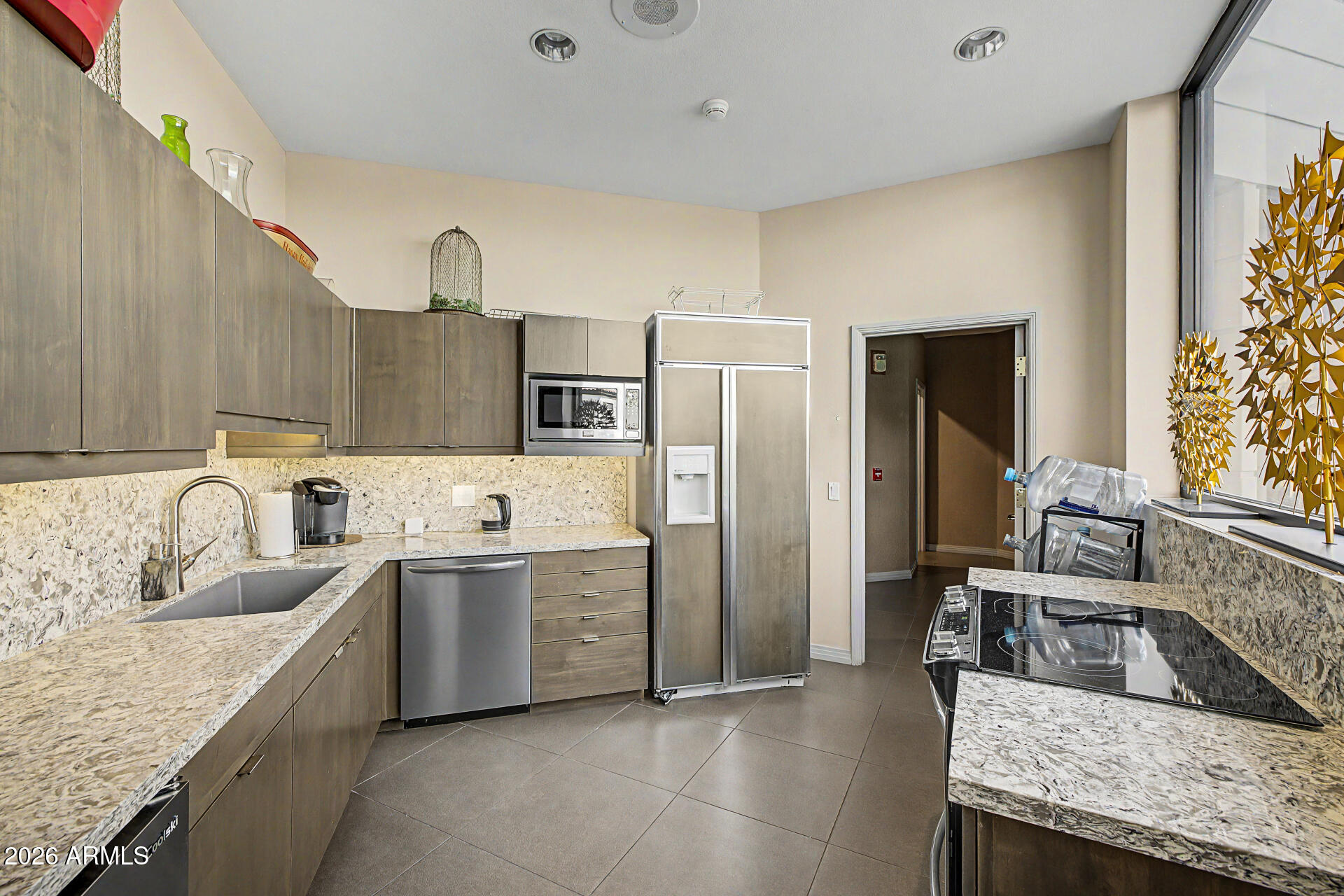 1040 East Osborn Road, Unit 402 Phoenix, AZ 85014 - Photo 71 of 96 a kitchen with stainless steel appliances granite countertop a sink and a refrigerator