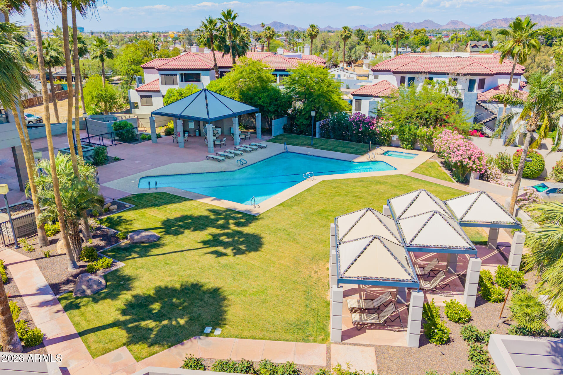 1040 East Osborn Road, Unit 402 Phoenix, AZ 85014 - Photo 90 of 96 a view of a swimming pool with a lawn chairs under an umbrella