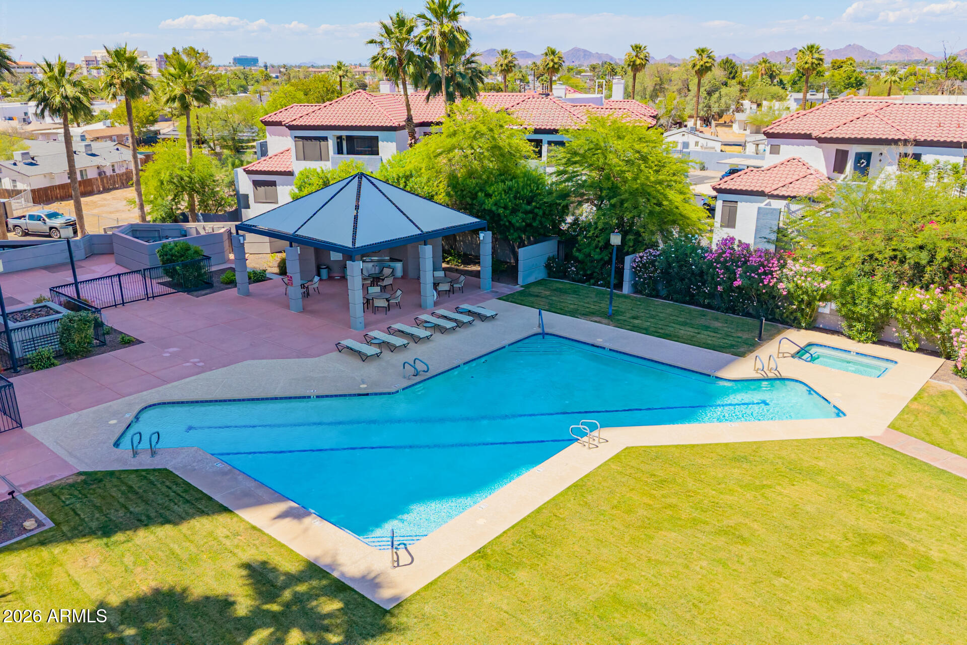 1040 East Osborn Road, Unit 402 Phoenix, AZ 85014 - Photo 91 of 96 a view of a swimming pool with a table and chairs under an umbrella