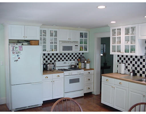 66 Robbins Road Watertown, MA 02472 - Photo 7 of 16 a kitchen with a refrigerator and white cabinets