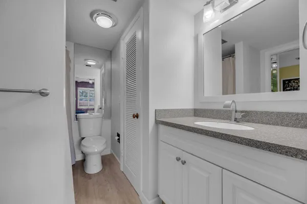 a bathroom with a granite countertop sink a toilet and shower
