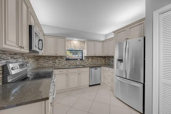 a kitchen with granite countertop cabinets and steel stainless steel appliances