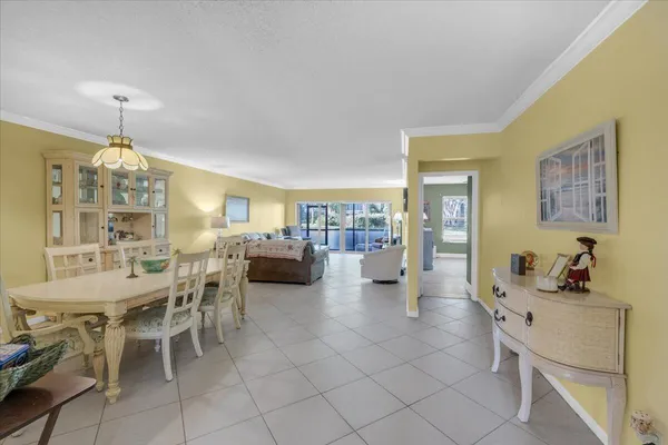 a view of a dining room and livingroom with furniture wooden floor a chandelier