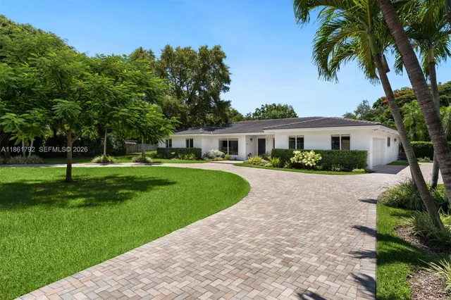 a front view of a house with a yard and trees
