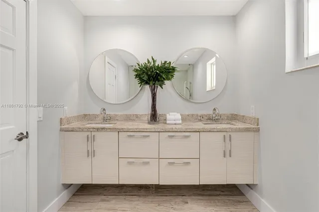 a bathroom with a granite countertop sink and a mirror