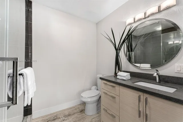 a bathroom with a toilet sink and mirror