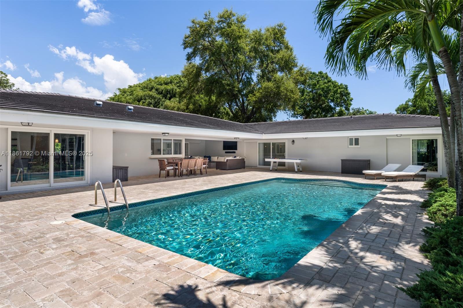 5940 Southwest 120th Street Pinecrest, FL 33156 - Photo 29 of 40 a front view of house with a garden and patio