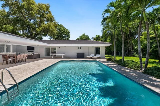 a view of a house with backyard and sitting area