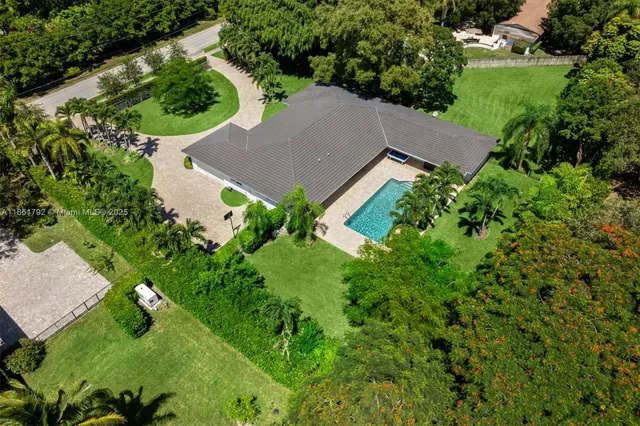 an aerial view of a house with a yard and outdoor seating