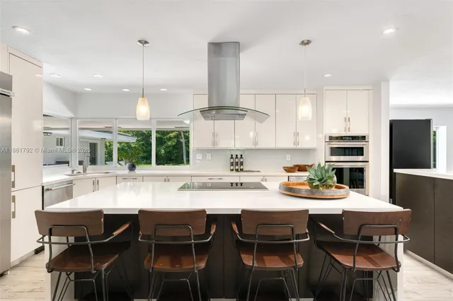 a kitchen with refrigerator a sink and chairs
