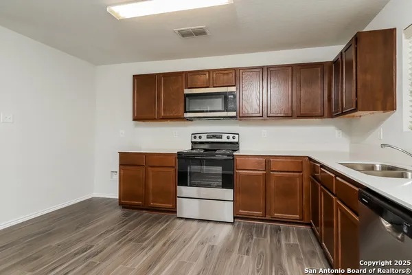 a kitchen with wooden floors and stainless steel appliances